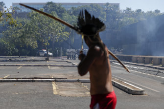 An Indigenous protester aims his bow an arrow at police outside Congress in Brasilia, Brazil.