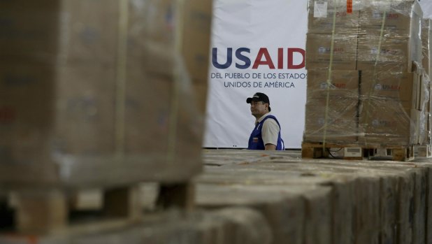 A man walks past boxes of USAID humanitarian aid at a warehouse at the Tienditas International Brigde on the outskirts of Cucuta, Colombia.