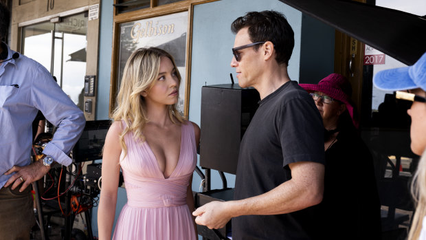 Director Will Gluck discusses a shot with Sydney Sweeney at Bondi Beach.
