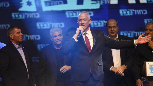 Blue and White party leaders, from the left, Gabi Ashkenazi, Yair Lapid, Benny Gantz (with the microphone) and Gabi Ashkenazi greet their supporters at party headquarters after the first results of the elections in Tel Aviv.