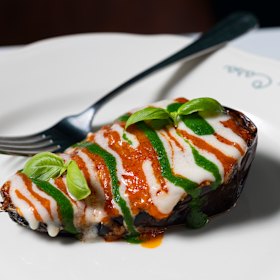 Eggplant parmigiana striped with Napoli sauce, cheese and basil.