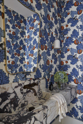 A new guest powder is room adorned with floral wallpaper that’s evocative of the 1920s.