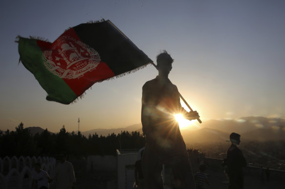 A man waves an Afghan flag in Kabul, Afghanistan, in August last year. In February, Afghanistan reported multiple American military deaths after an insider attack by a man wearing an Afghan army uniform.