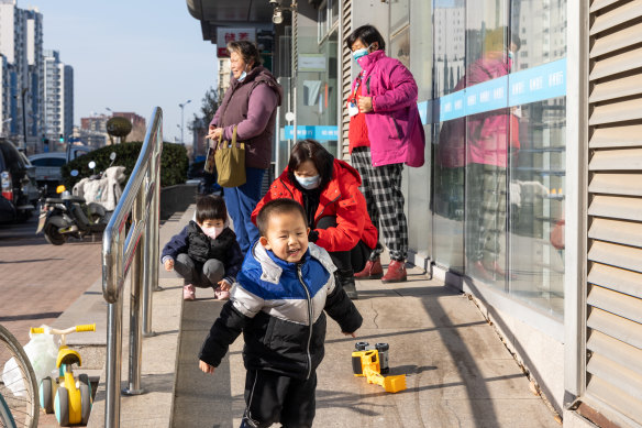 Children play in Beijing as their parents pick up supplies from the pharmacy. 