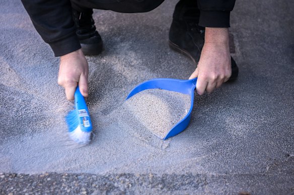 There is so much sand outside Moore’s shop he has to scoop it up.