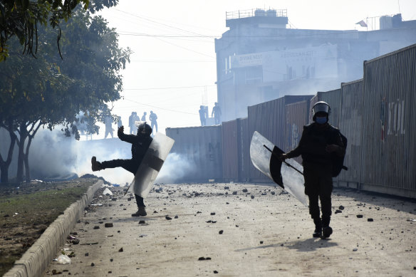 Police officer throw stones towards the supporters of Imran Khan during clashes outside a court in Islamabad on Saturday.
