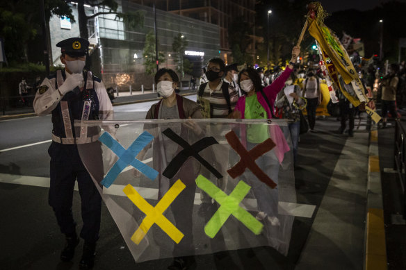 Demonstrators march around the New National Stadium, the main stadium for the Tokyo Olympics, during a protest against the Tokyo Olympics on Sunday, May 09.