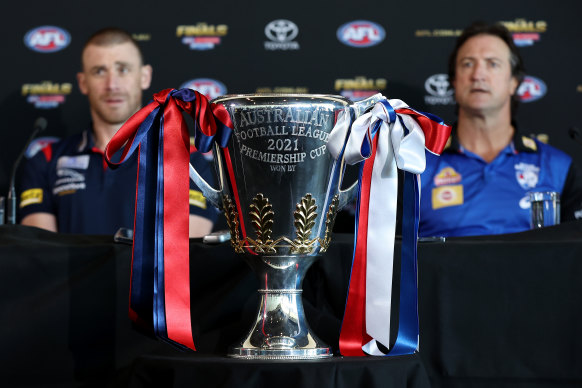 Melbourne coach Simon Goodwin and Bulldogs counterpart Luke Beveridge flank the premiership cup on Friday.