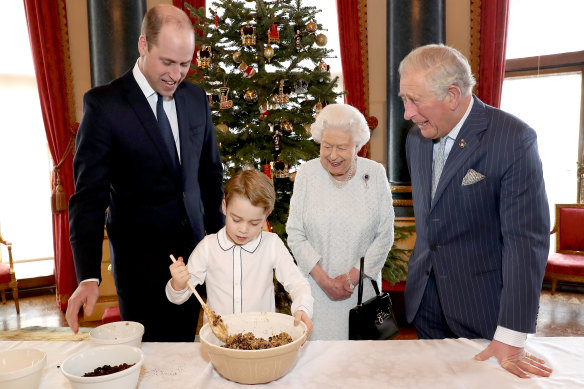 Prince William, Prince George, the Queen and Prince Charles prepare special Christmas puddings in the Music Room at Buckingham Palace.