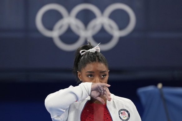 Simone Biles watches after exiting the team final.
