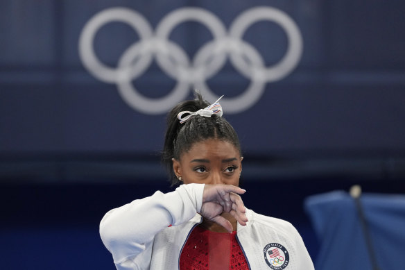 Simone Biles watches on after exiting the team final.