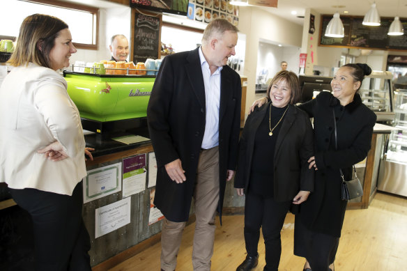 Kristy McBain looks on as Opposition Leader Anthony Albanese meets with some fans at a cafe in Cooma.