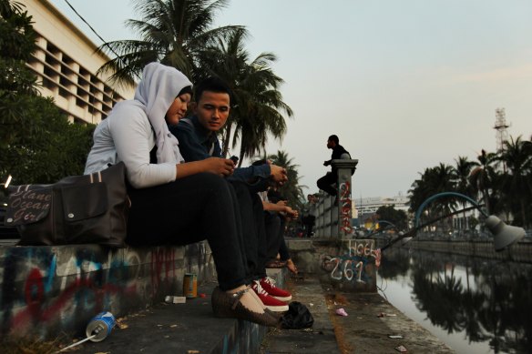 A couple sit by a Dutch-built colonial-era canal in Jakarta in 2012.