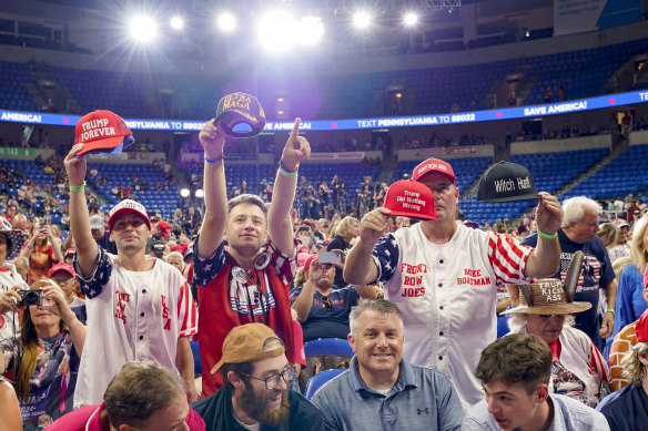 Supporters of former president Donald Trump wave their Make America Great Again hats at the Pennsylvania rally.