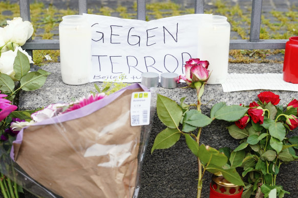 Candles, flowers and a piece of paper with the inscription “Against Terror” stand at the scene of the crime on the market square in Mannheim, Germany.