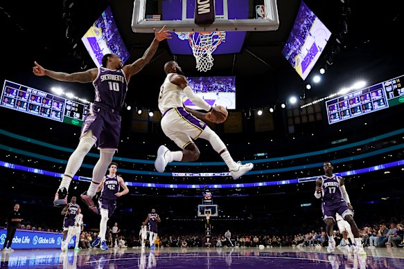 LeBron James dunks the ball against Demar Derozan of the Sacramento Kings.