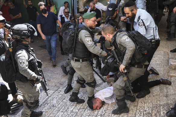 Israeli police officers detain a Palestinian youth during a protest against Israel’s air strikes on the Gaza Strip and the violent confrontations between Israeli security forces and Palestinians, in Jerusalem’s Old City on Tuesday.
