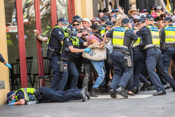 One police officer on the ground during a scuffle between lockdown protesters and police on Tuesday.
