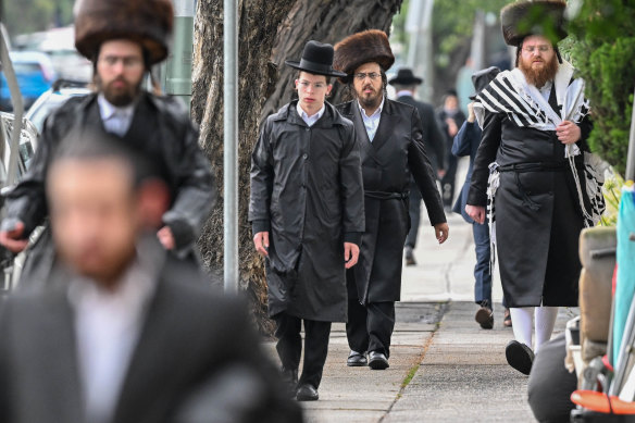 Members of the Adass Israel congregation walk to their temporary space for synagogue services on Saturday.