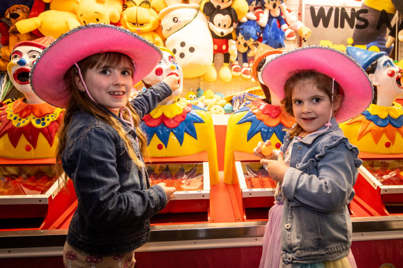 Chloe (left) and Olivia Alabakis try the amusements on offer at this year’s Melbourne Royal Show.
