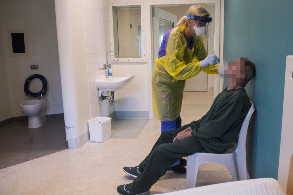 Dr Mica Spasojevic takes a swab from an inmate for a COVID-19 test at Long Bay prison hospital.