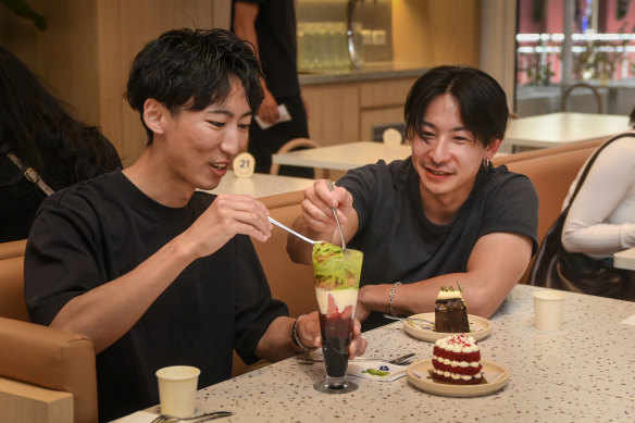 Friends Toma Takahashi (left) and Genki Horie enjoy the desserts at Amiri Cafe.