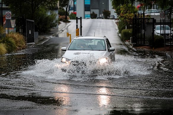 A car drives through floodwater on Lloyd Street in Kensington.