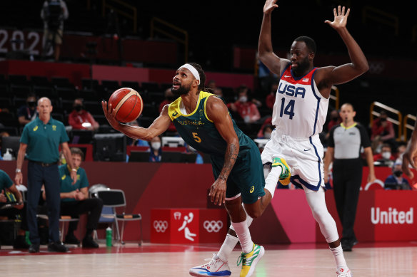 Draymond Green fouls Australia’s Patty Mills.