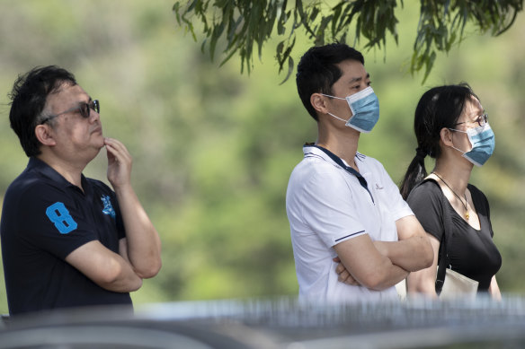 Parents wait outside Epping Boys High School to collect their sons returning from year 9 camp. 