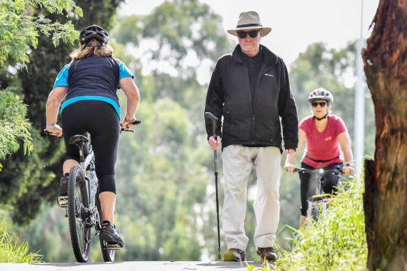 Joe Meakin passes cyclists on his daily walk in Eltham. 