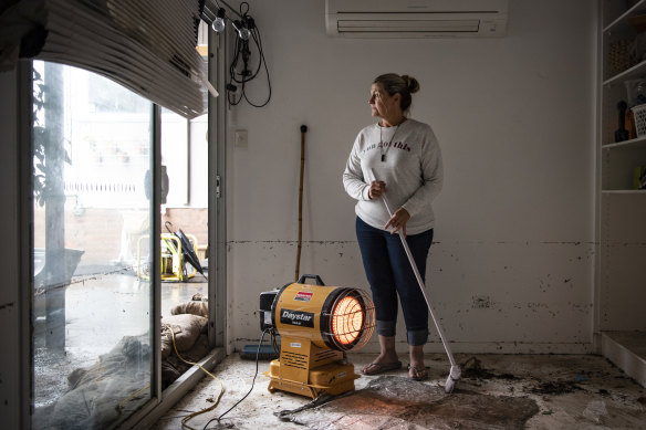 Kate Connell cleans out her flood damaged home after rising waters entered from Peach Tree Creek. 