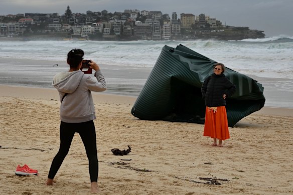 A water tank washed onto Bondi Beach becomes an instant attraction.
