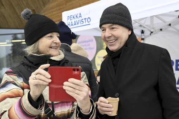 Greens Party presidential candidate Pekka Haavisto (right) poses for a selfie.