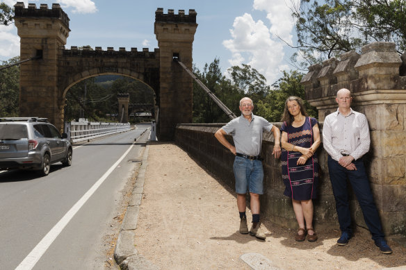 Kangaroo Valley residents Gary Moore, Kate Watson and Matt Gray near the town's Hampden Bridge. The wooden structure is the sole bridge across the Kangaroo River and carries a major water pipe. 