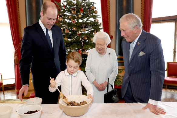 Prince William, Prince George, Queen Elizabeth II and Prince Charles prepare Christmas puddings in the Music Room at Buckingham Palace in December 2019. 