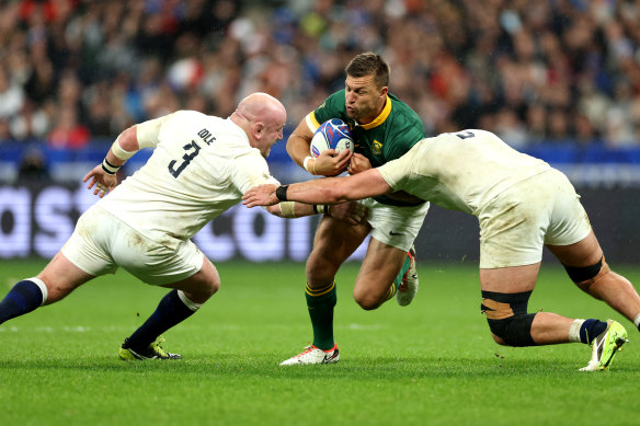 Handre Pollard of South Africa is tackled by Dan Cole and George Martin.