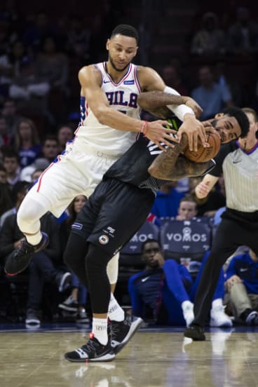 Simmons tangles with Melbourne United's DJ Kennedy in a preseason game.