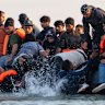 Migrants board a small boat bound for the United Kingdom off the shoreline of Gravelines beach in Calais, France, on July 17.