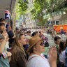 A crowd lines Brisbane’s Adelaide Street and pedestrian walkways to recognise Australian and New Zealand troops and their families on Anzac Day.