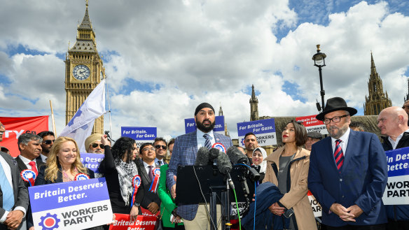 Leader of the Workers Party of Britain George Galloway (right) looks on as former England cricketer Monty Panesar (centre) addresses fellow party candidates in Parliament Square.