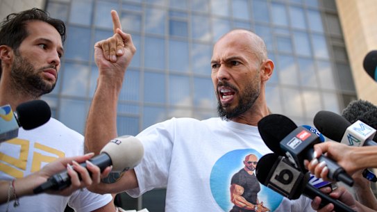 Andrew Tate speaks to media, next to his brother Tristan, left, outside the Bucharest Tribunal after being placed under house arrest.