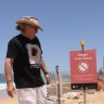 Surfrider Foundation Australia northern beaches president Brendan Donohoe stands next to a warning sign at Collaroy Beach.