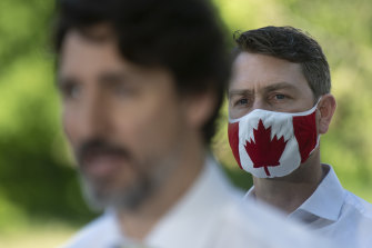 William Amos, wearing a Canadian mask and standing behind PM Justin Trudeau, has apologised again after an on-screen gaffe.