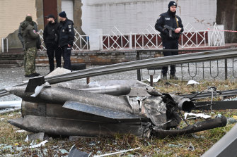 Police and security personnel inspect the remains of a shell landed in a street in Kyiv.