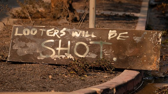A homemade sign sits on the ground near homes destroyed by the Palisades fire in Los Angeles. 