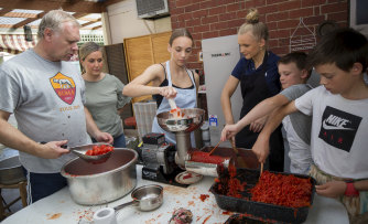 Happily chaotic: Mark Salvati, left, and relatives making passata at the home of Mark's mother, Lucia Salvati, in Fairfield.