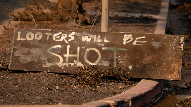 A homemade sign sits on the ground near homes destroyed by the Palisades fire in Los Angeles. 
