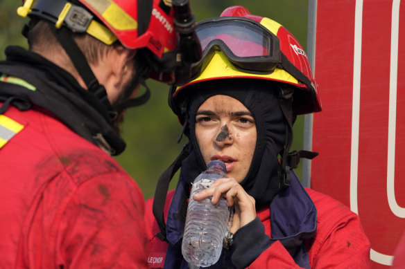 Firefighters take a break after battling a forest fire that flared anew in the village of Lagoa Parada, near Ansiao, central Portugal.