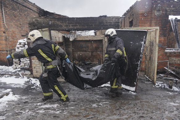 Firefighters carry a body of a resident killed in a fire as a Russian drone hit his home in a residential neighbourhood, in Kharkiv, Ukraine.