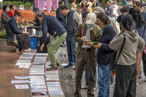 People peruse the rows of signs advertising would-be wives and husbands at the marriage market in Shanghai’s People’s Park, while some exchange contact details in hope of lining up a meeting between the two parties. 